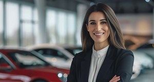 Professional businesswoman in a luxury high-end auto dealership, surrounded by expensive cars. 