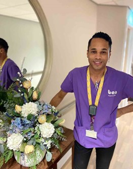 House leader in care centre standing by a vase of flowers