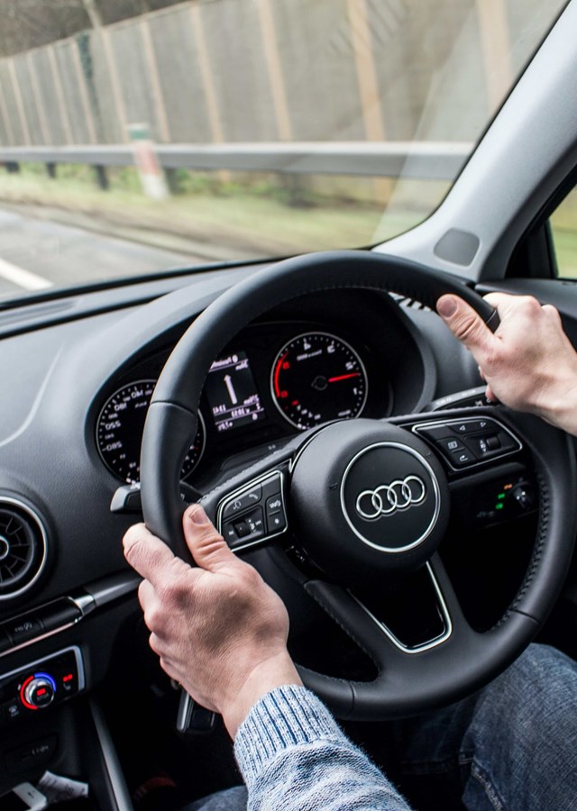 Person driving along a road, following directions on their satnav