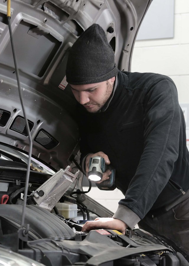 Garage technician looking at a car engine to diagnose issue. Demonstrating skills that can be used in other job roles, sectors and industries.